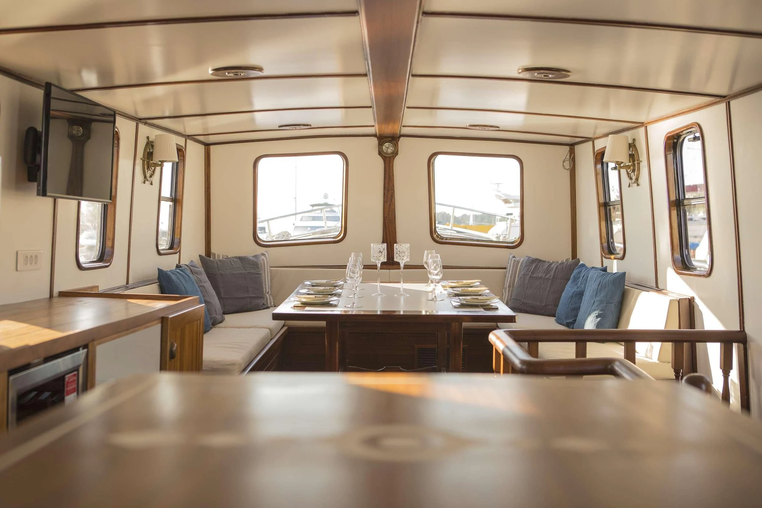 a room with a table and couch aboard COSMOS Yacht for Sale