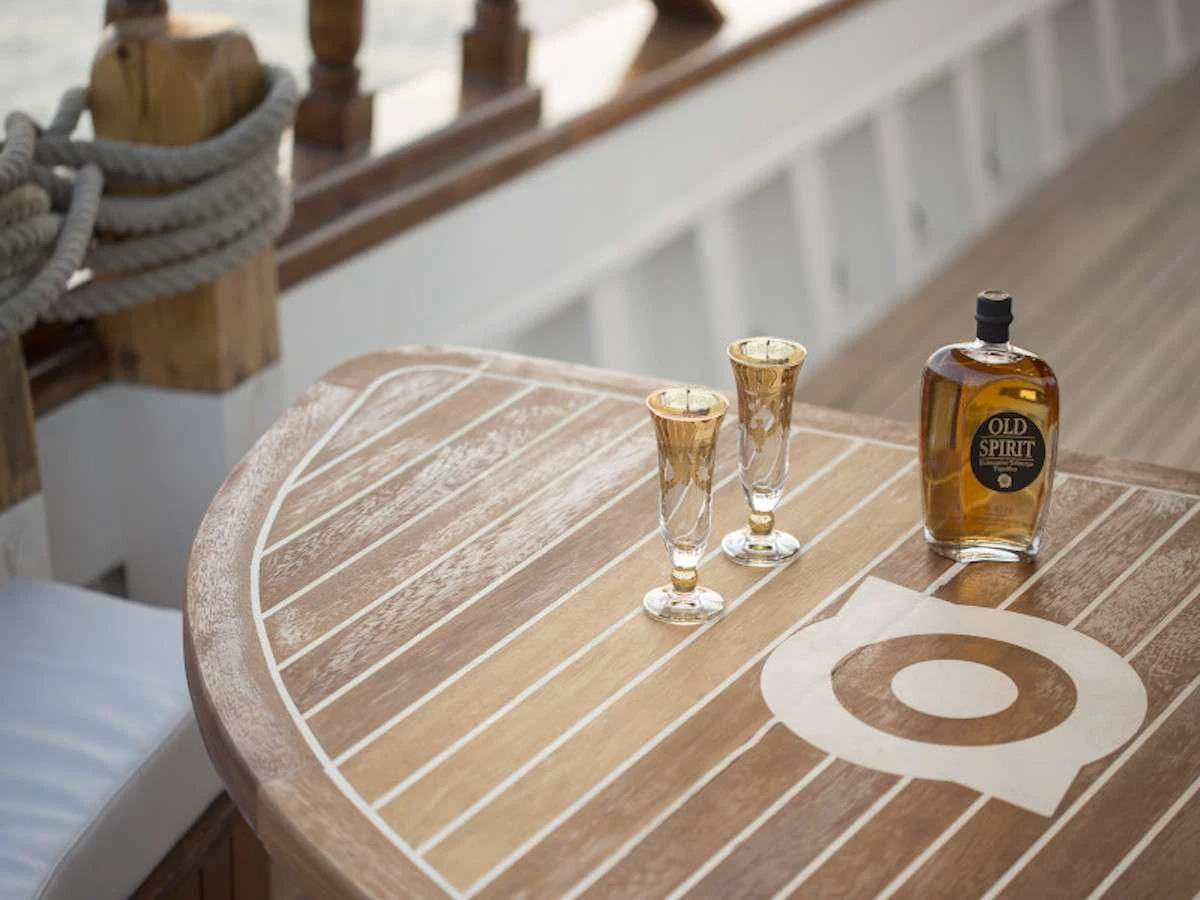 a glass of beer and a bottle on a table aboard COSMOS Yacht for Sale