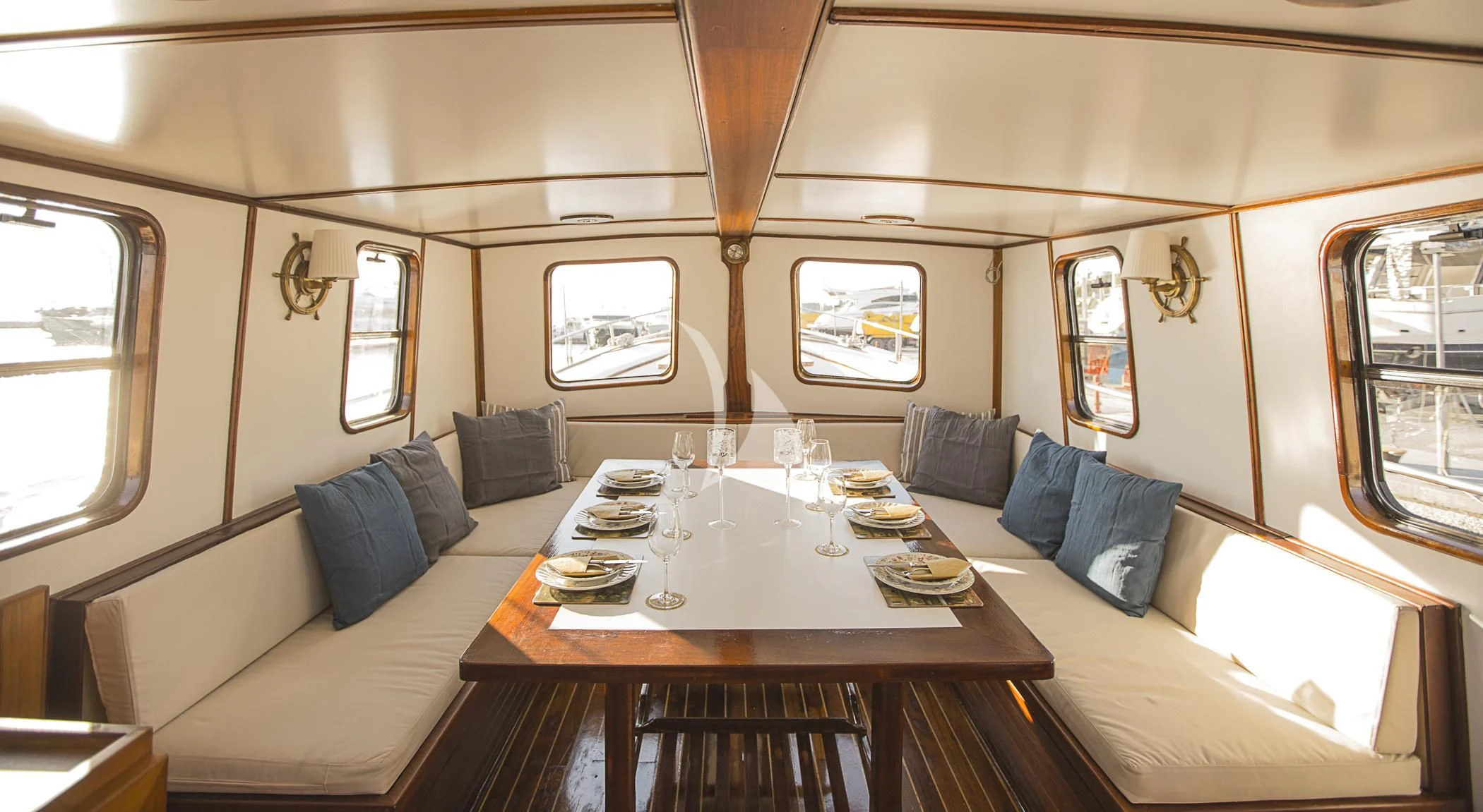 a room with a table and couch aboard COSMOS Yacht for Sale