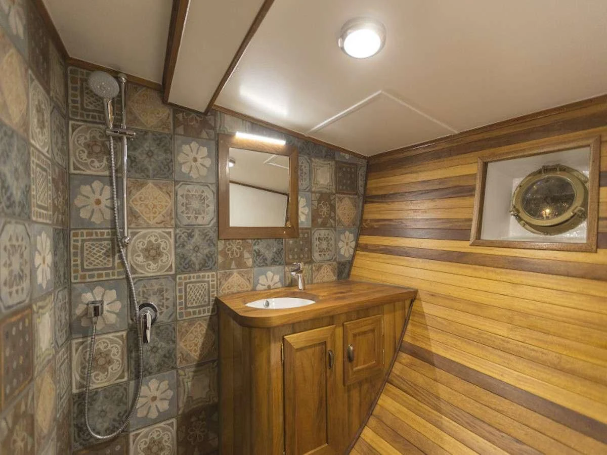 a bathroom with a marble wall aboard COSMOS Yacht for Sale