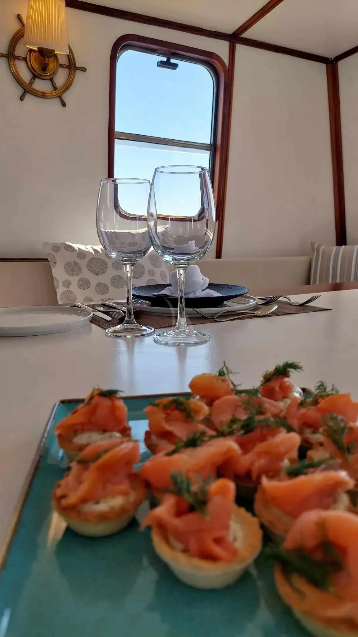 a table with food and glasses aboard COSMOS Yacht for Sale