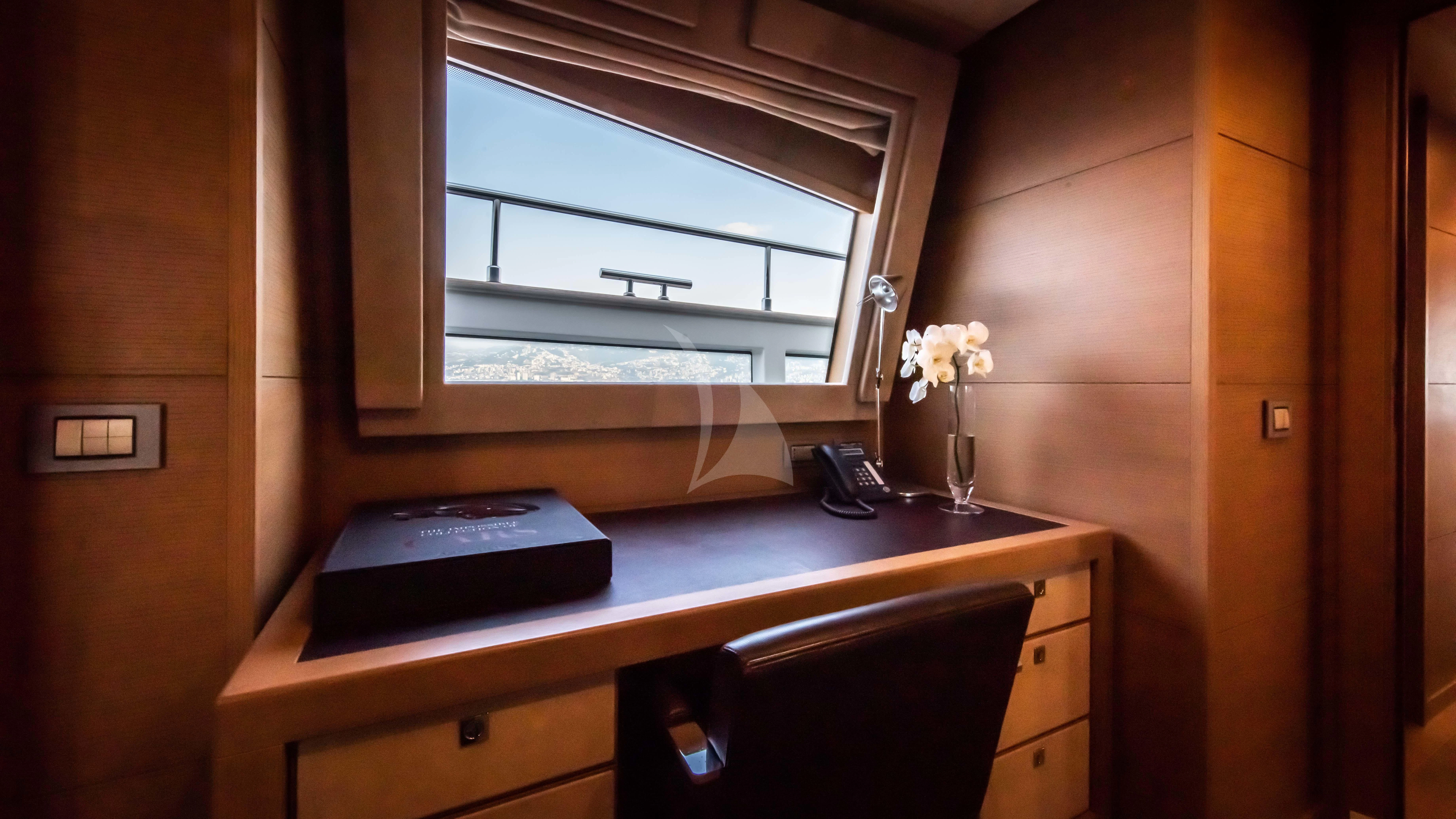 a desk with a phone and a laptop on it aboard THALYSSA Yacht for Charter