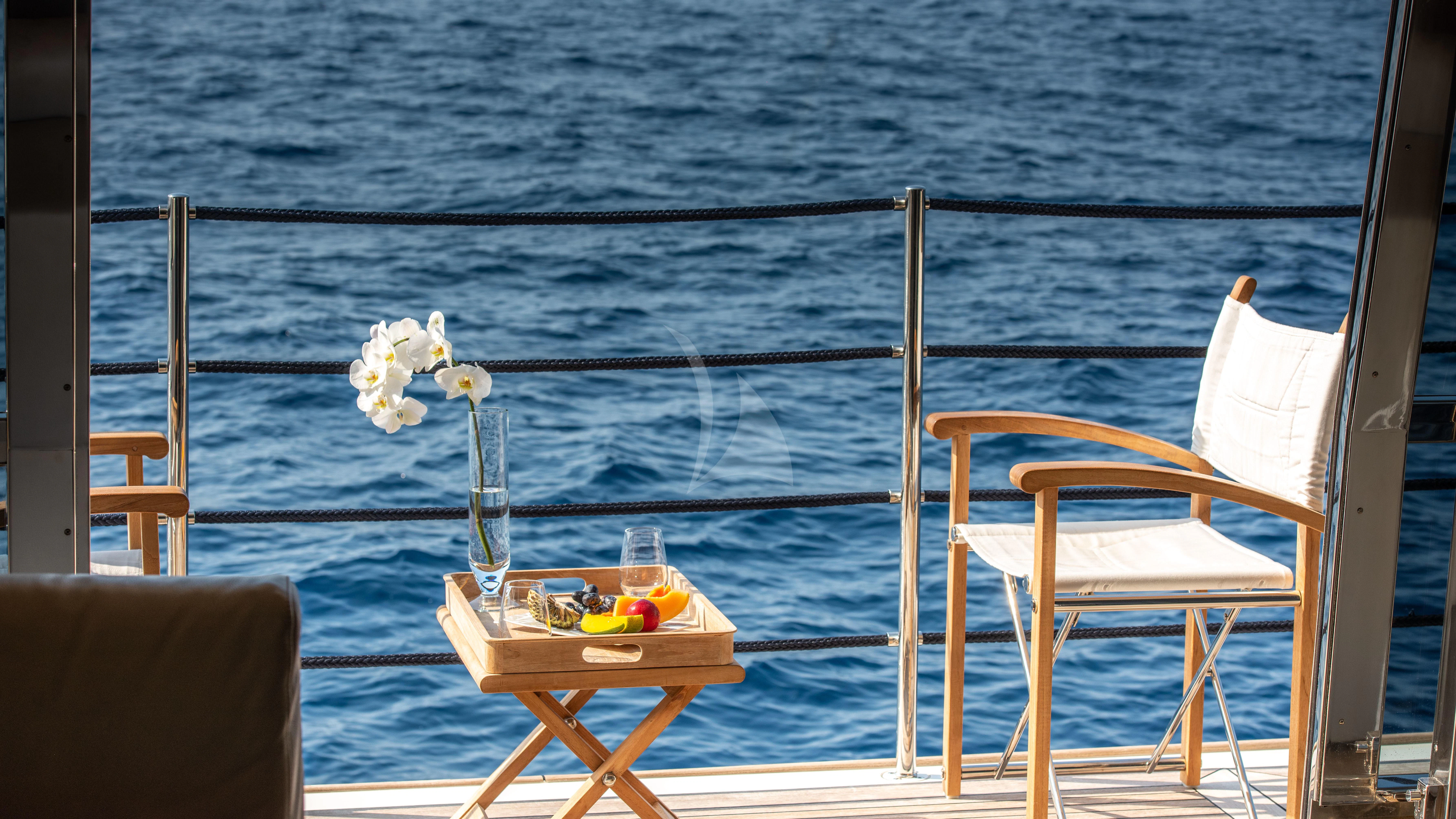a table and chairs on a beach aboard THALYSSA Yacht for Charter