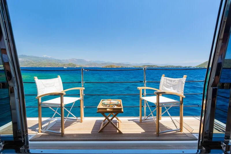 a deck with chairs and a table on it aboard THALYSSA Yacht for Charter