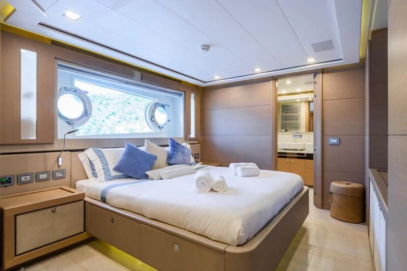 a bedroom with a bed and a window aboard THALYSSA Yacht for Charter