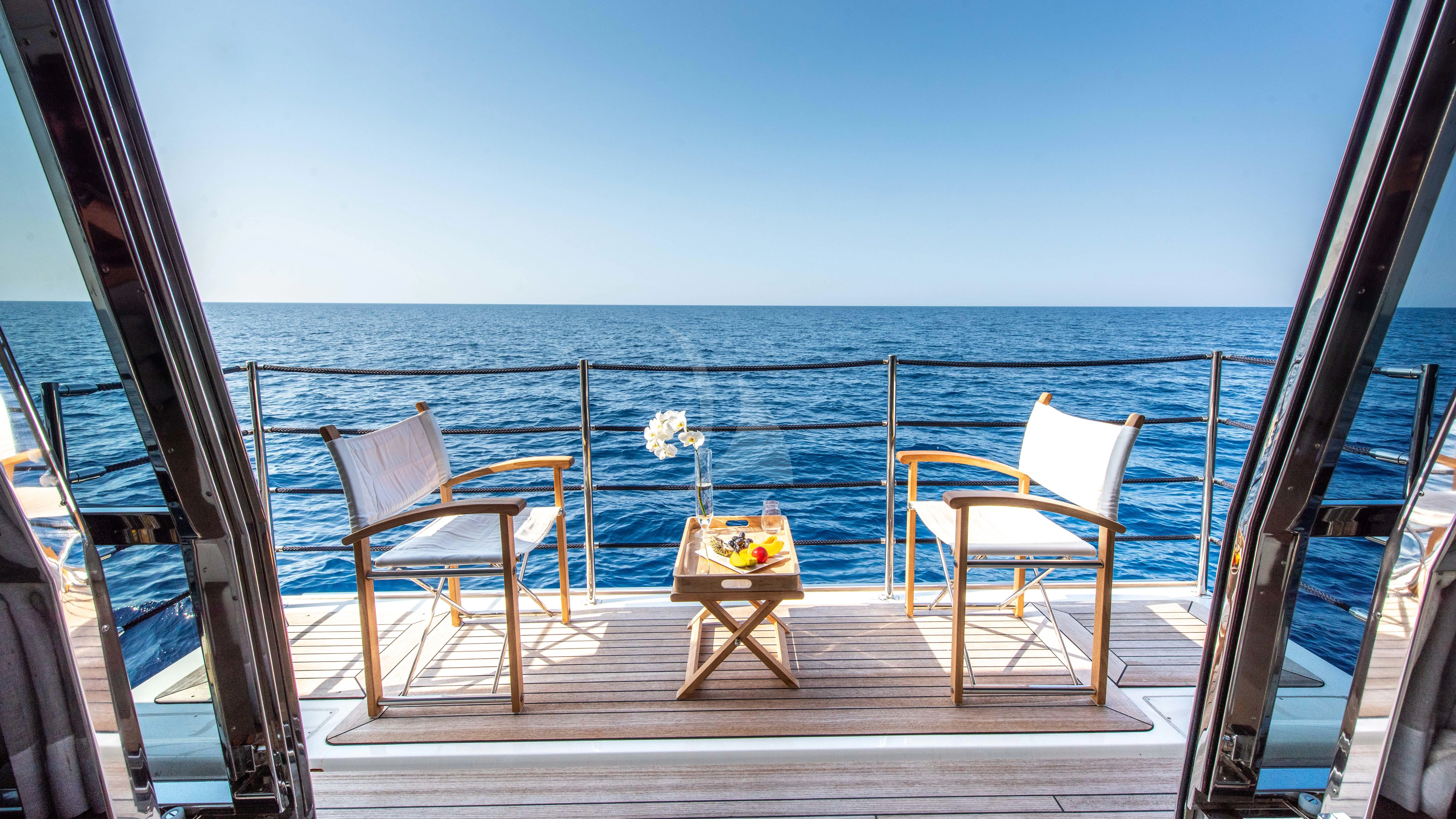 a deck with chairs and a table on it aboard THALYSSA Yacht for Charter