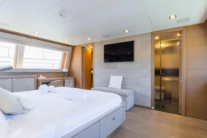 a room with a bed and a television aboard THALYSSA Yacht for Charter