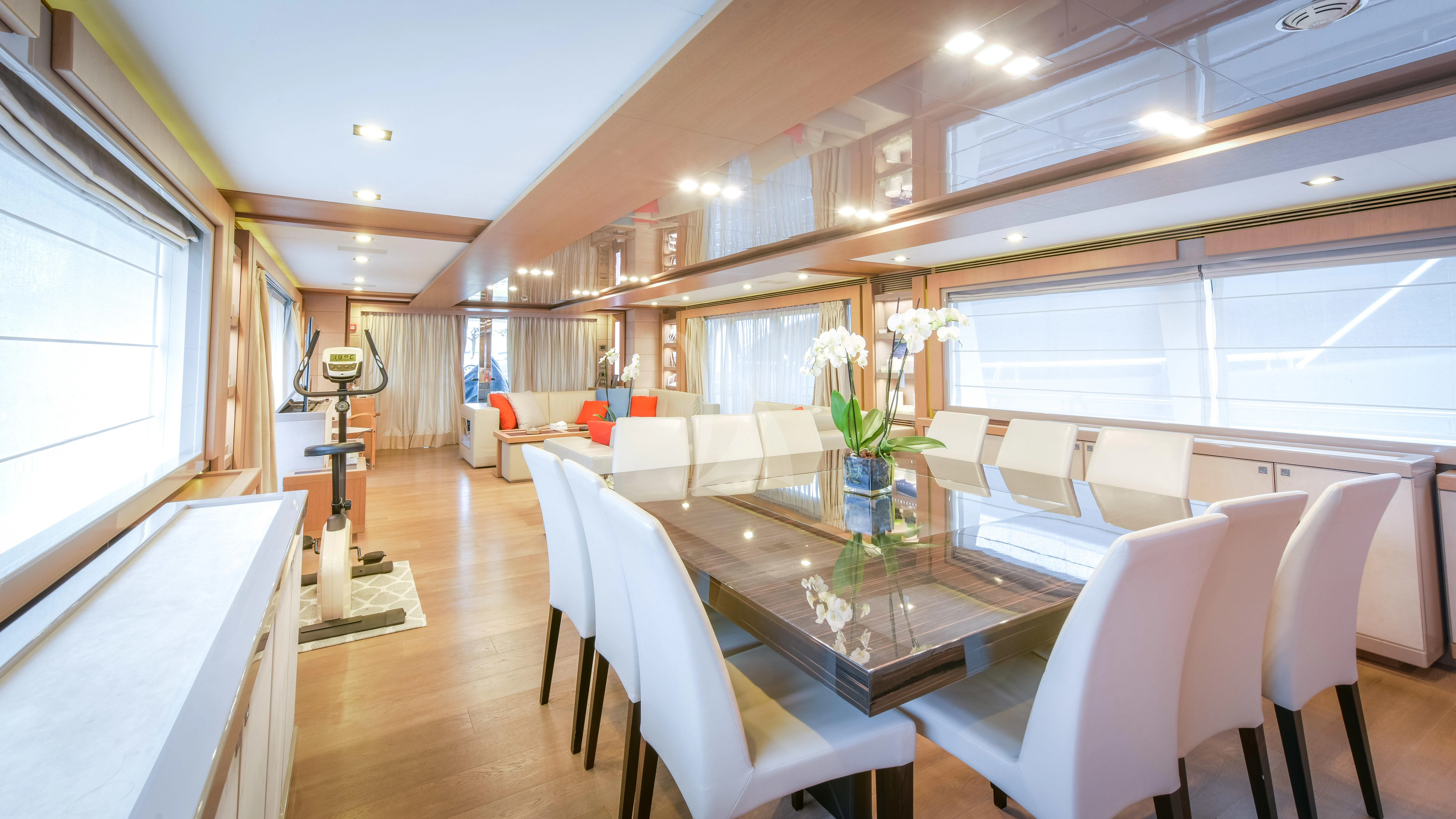a room with a table chairs and flowers in it aboard THALYSSA Yacht for Charter