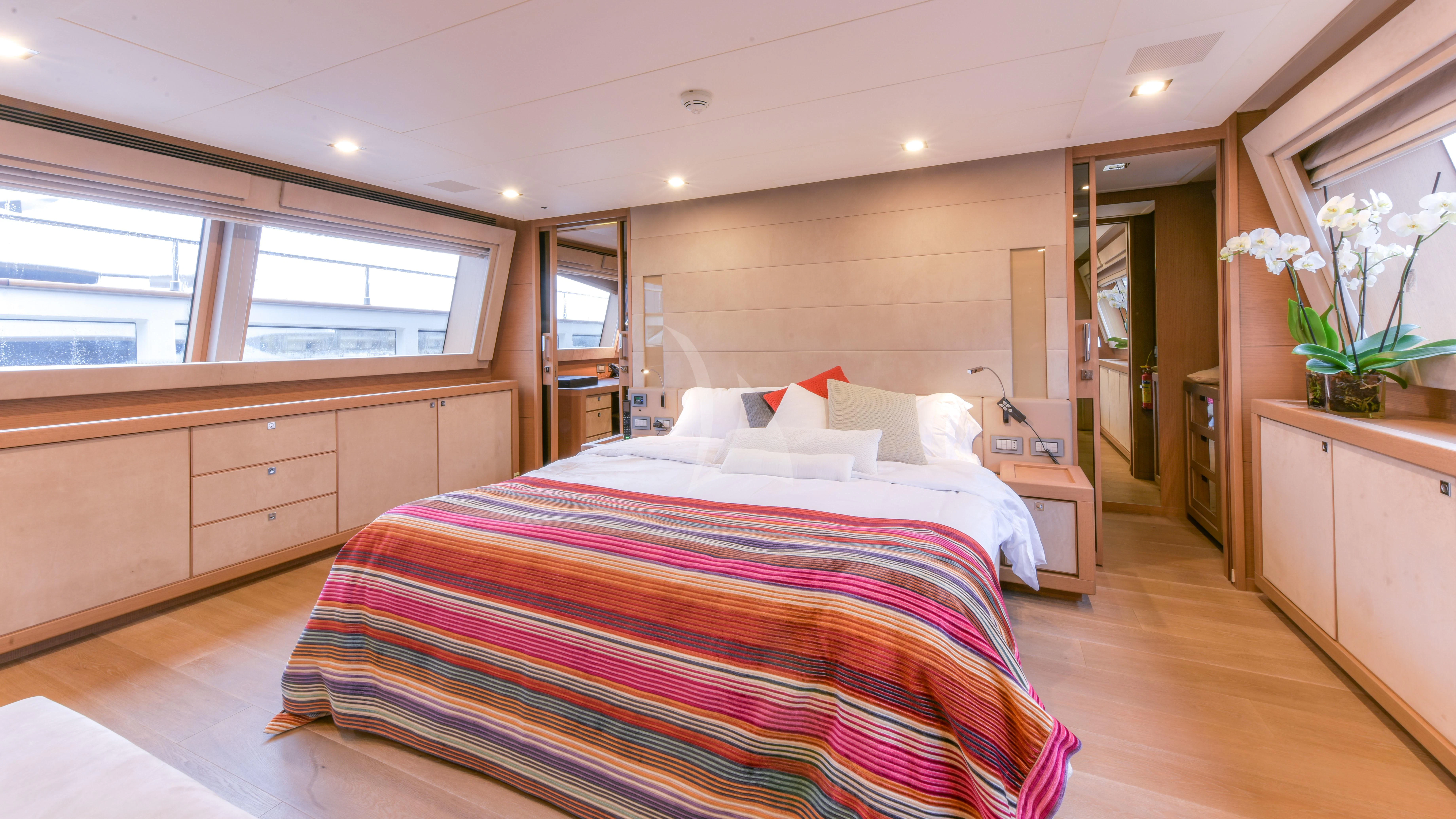 a bedroom with a bed and a desk aboard THALYSSA Yacht for Charter