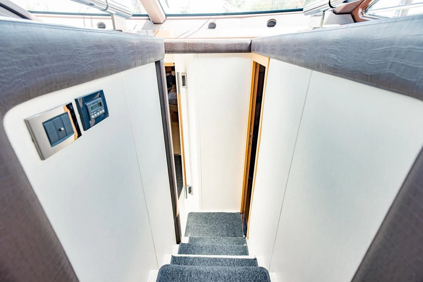 a room with a blue rug and a white wall with a black rug aboard SYLVIA VI Yacht for Sale