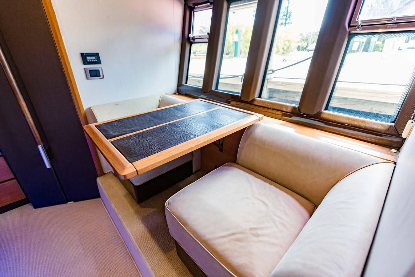 a couch and a coffee table in a room with windows aboard SYLVIA VI Yacht for Sale