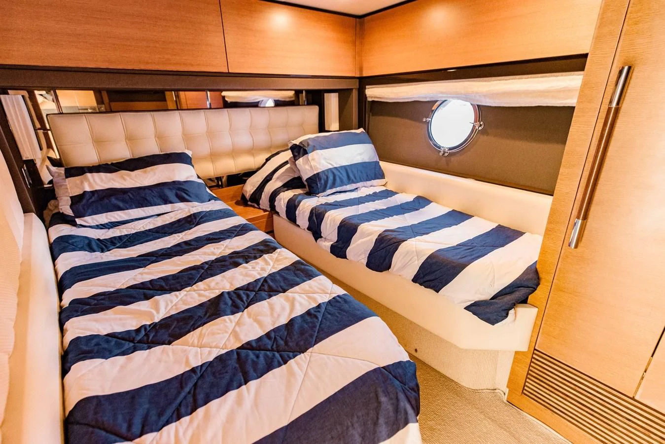a bed with blue and white striped sheets aboard SYLVIA VI Yacht for Sale