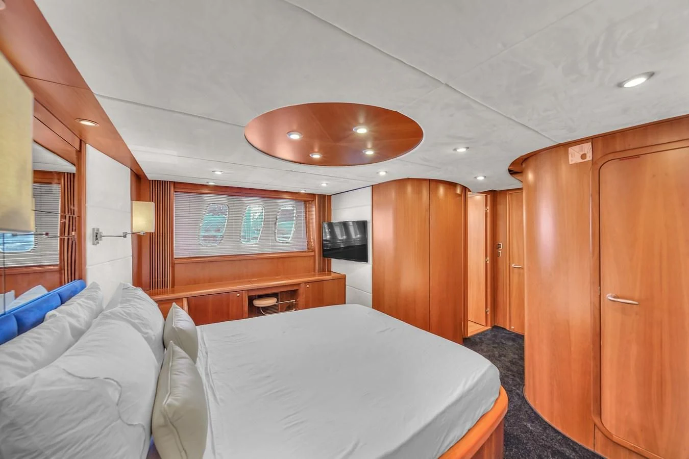 a bedroom with a bed and a wood cabinet aboard 82' SUNSEEKER PREDATOR 82 Yacht for Sale