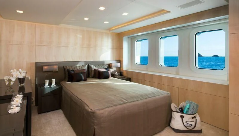 a bedroom with a bed and a window aboard SIREN Yacht for Sale