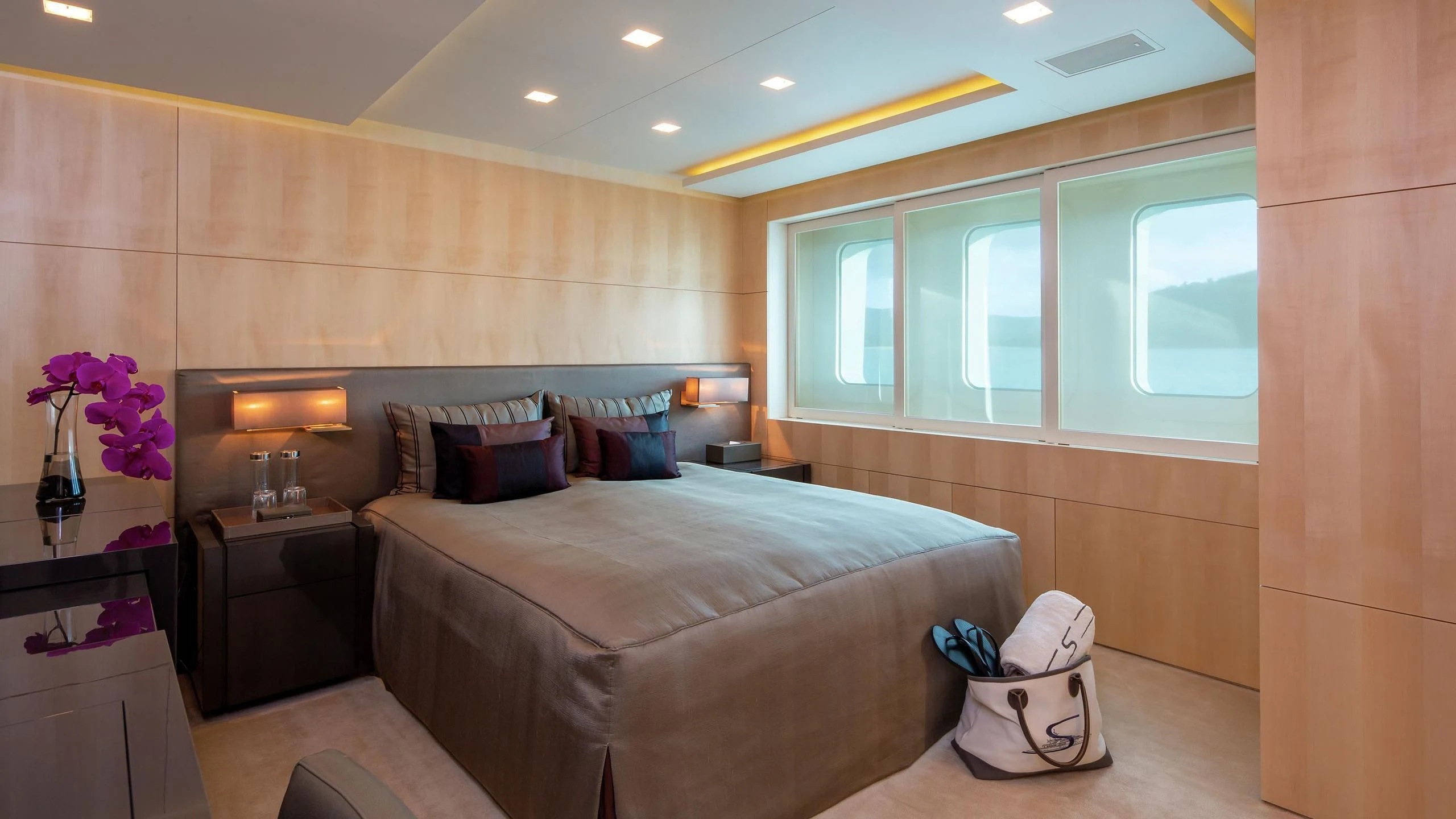 a bedroom with a bed and a chair aboard SIREN Yacht for Sale