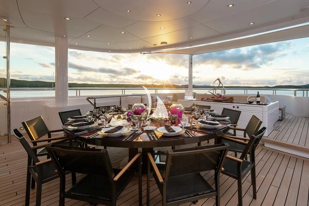 a dining table on a deck aboard SIREN Yacht for Sale