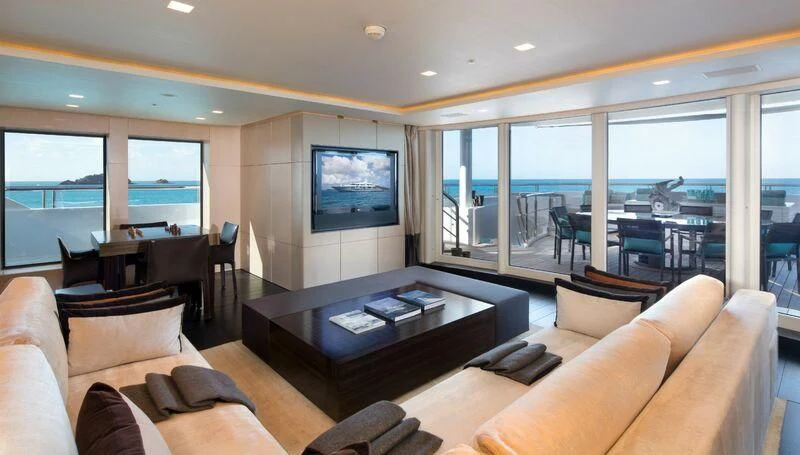 a living room with a table and couches aboard SIREN Yacht for Sale
