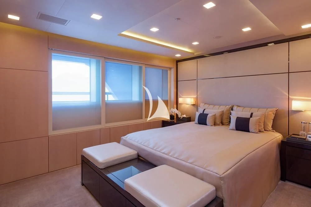 a bedroom with a bed and a window aboard SIREN Yacht for Sale