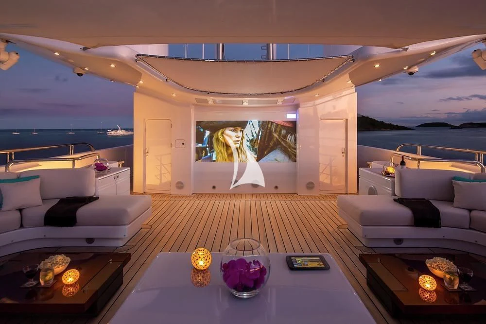 a room with a table and a couch and a large body of water aboard SIREN Yacht for Sale