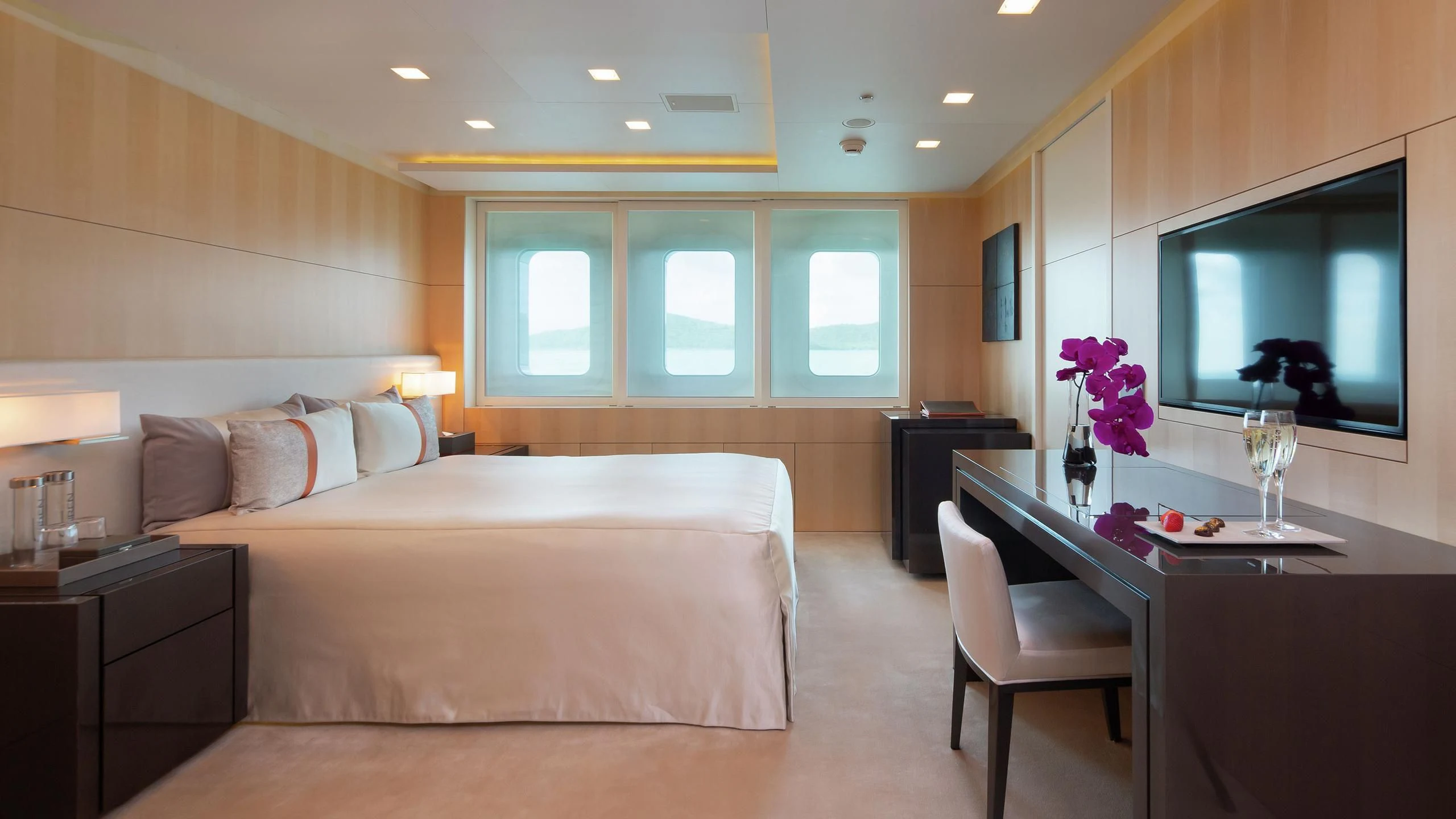 a large bedroom with a bed and a desk aboard SIREN Yacht for Sale