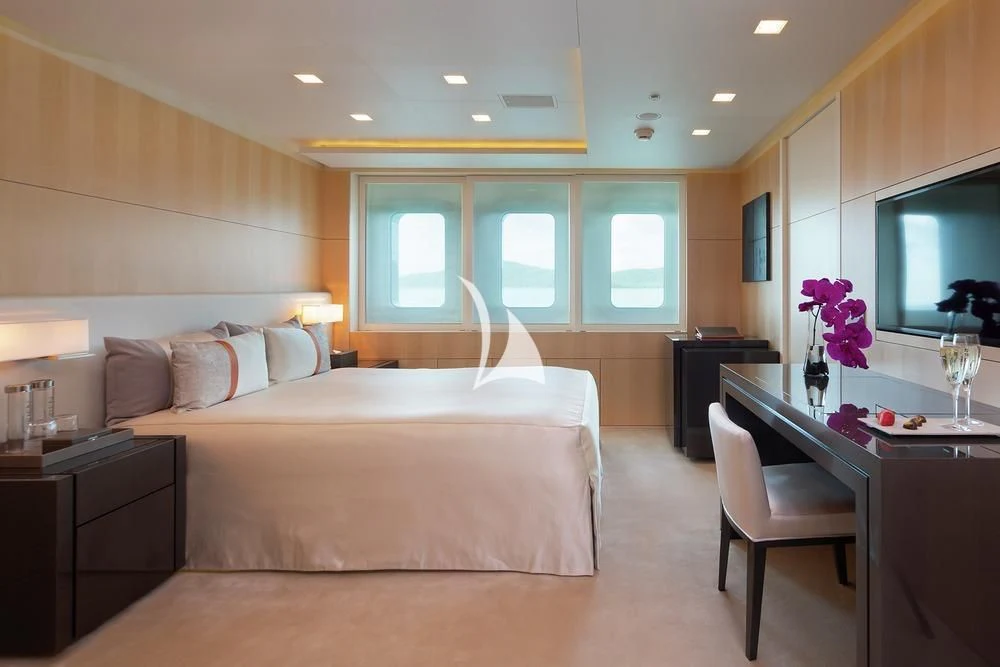 a bedroom with a bed and a desk aboard SIREN Yacht for Sale