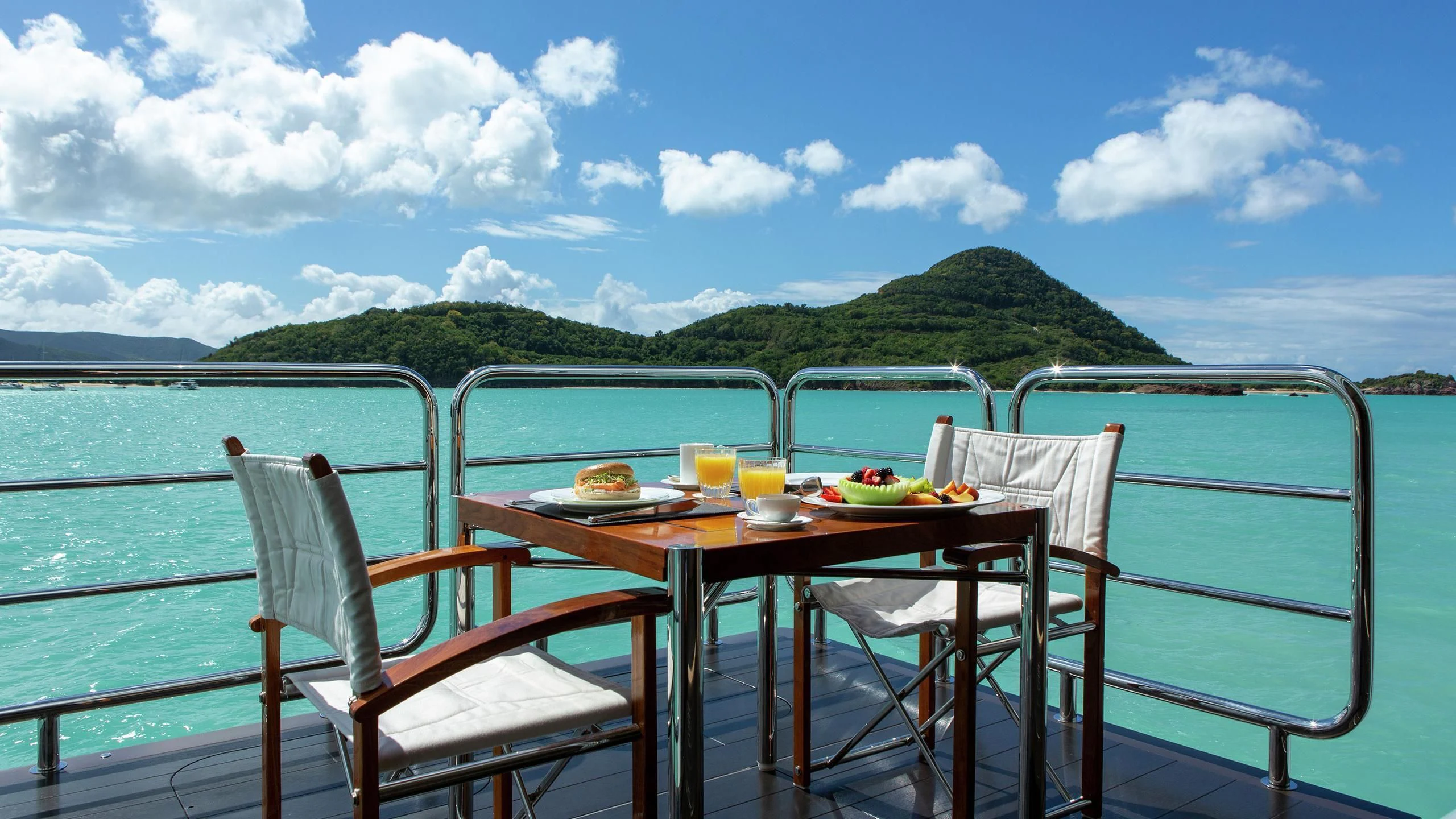 a table on a deck overlooking the ocean aboard SIREN Yacht for Sale