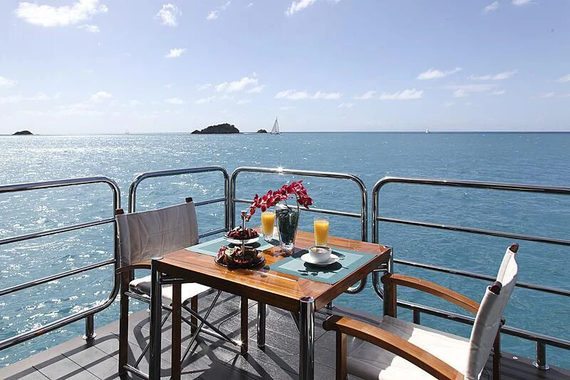 a table with a drink on it by the water aboard SIREN Yacht for Sale