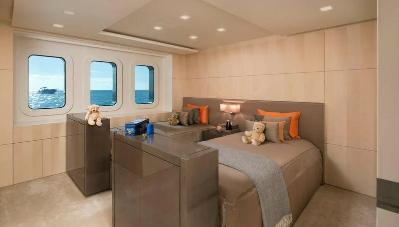 a bedroom with a bed and desk aboard SIREN Yacht for Sale