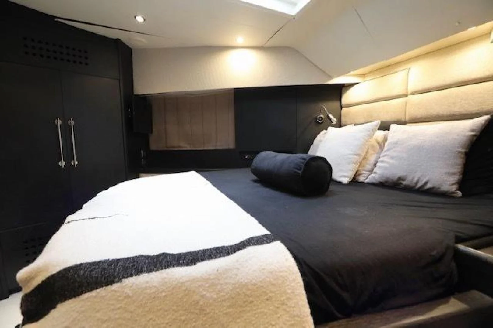 a room with a bed and a black cabinet aboard K3 Yacht for Sale