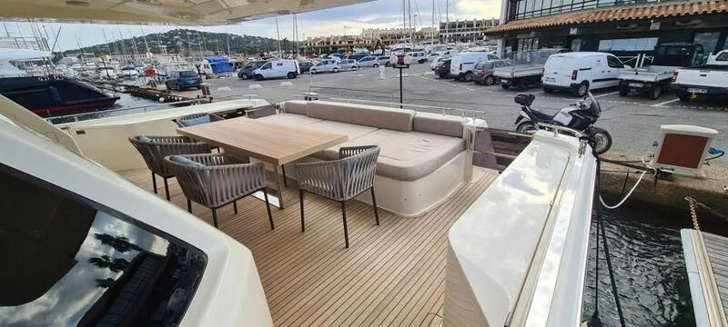 a deck with a table chairs and a bench on it aboard WATERMACHINE Yacht for Sale