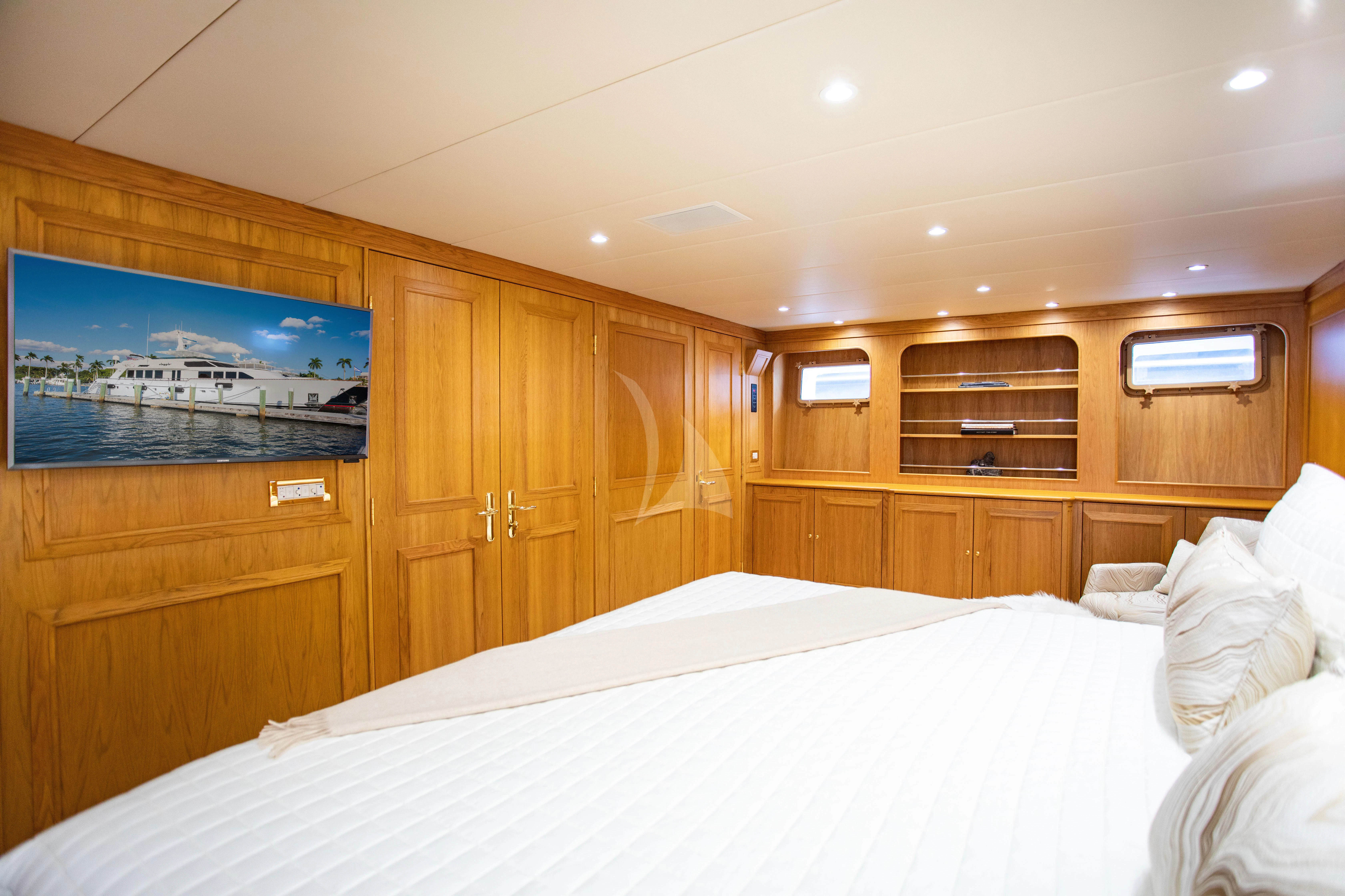 a room with a bed and a television aboard VIAGGIO Yacht for Sale