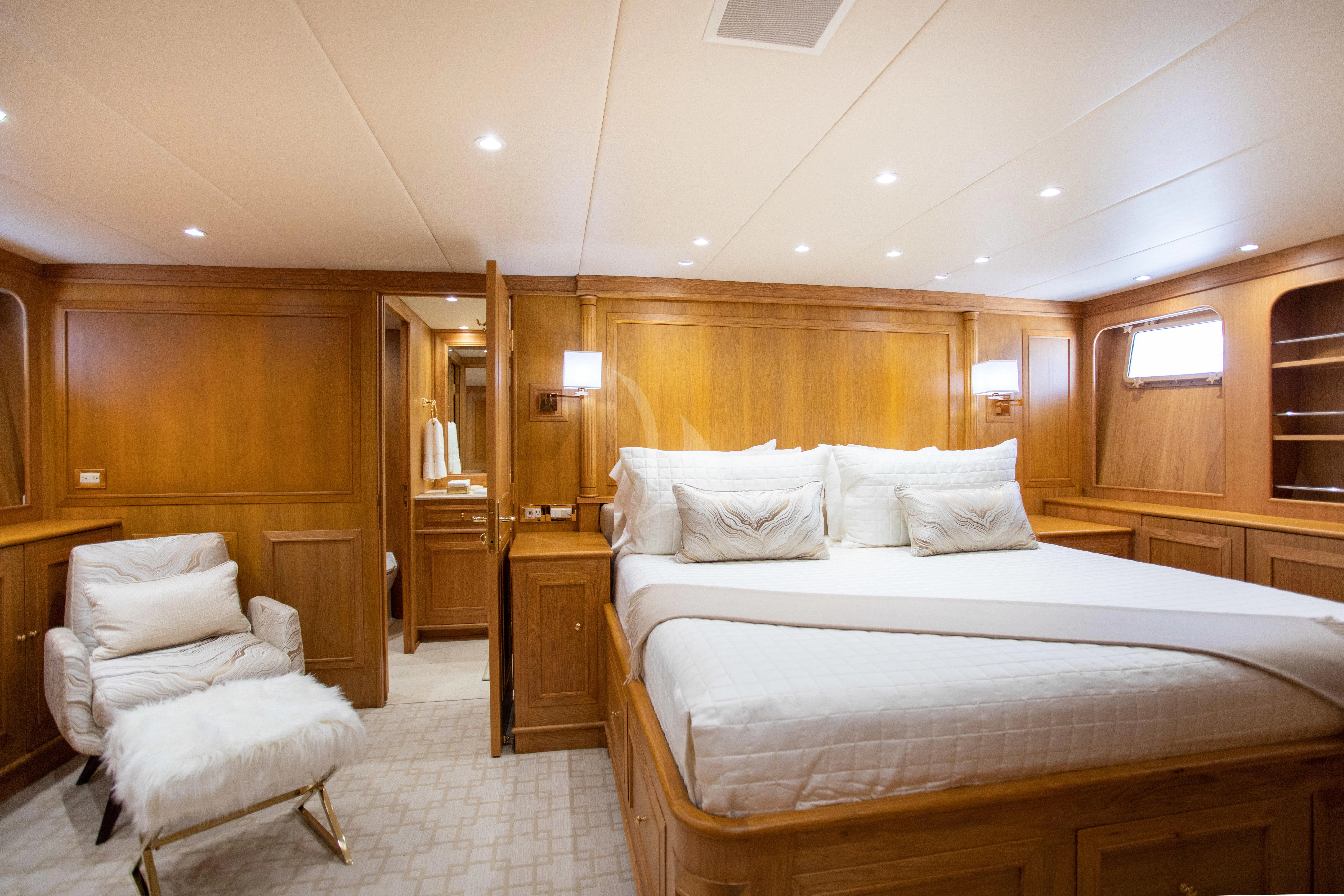 a bedroom with a bed and a chair aboard VIAGGIO Yacht for Sale