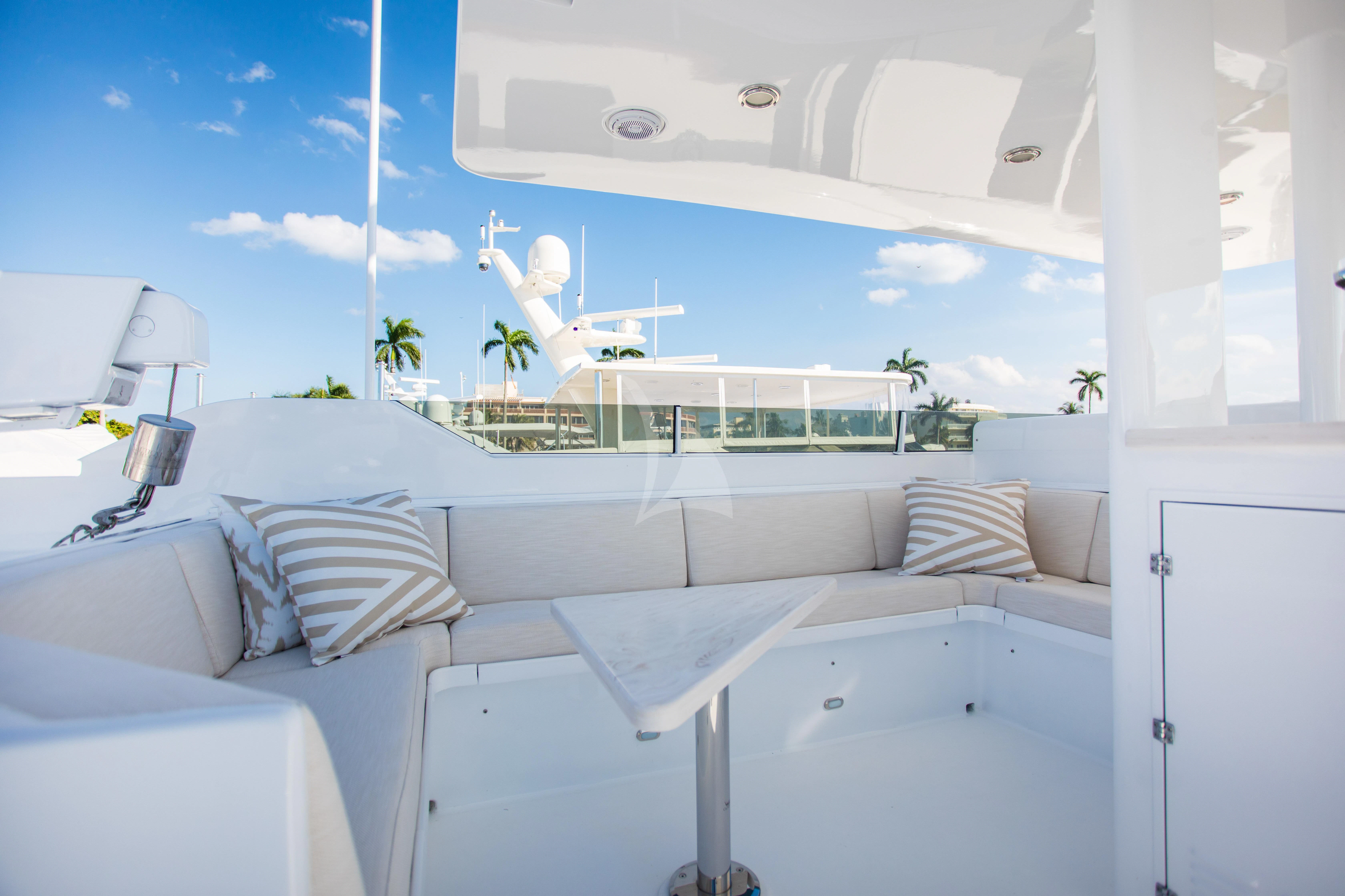 a white lounge chair next to a pool with a large white lounge chair and a white table and aboard VIAGGIO Yacht for Sale