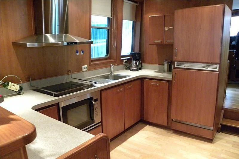 a kitchen with wooden cabinets aboard TRINTEL Yacht for Sale