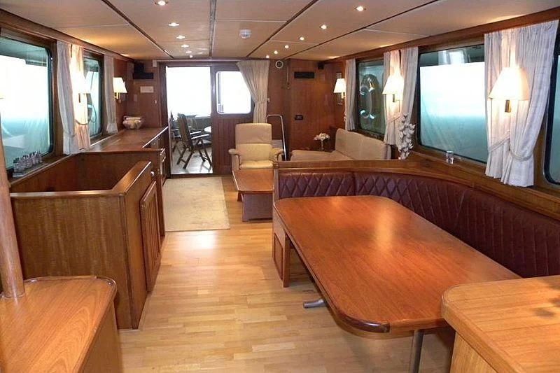 a large room with a table and chairs aboard TRINTEL Yacht for Sale
