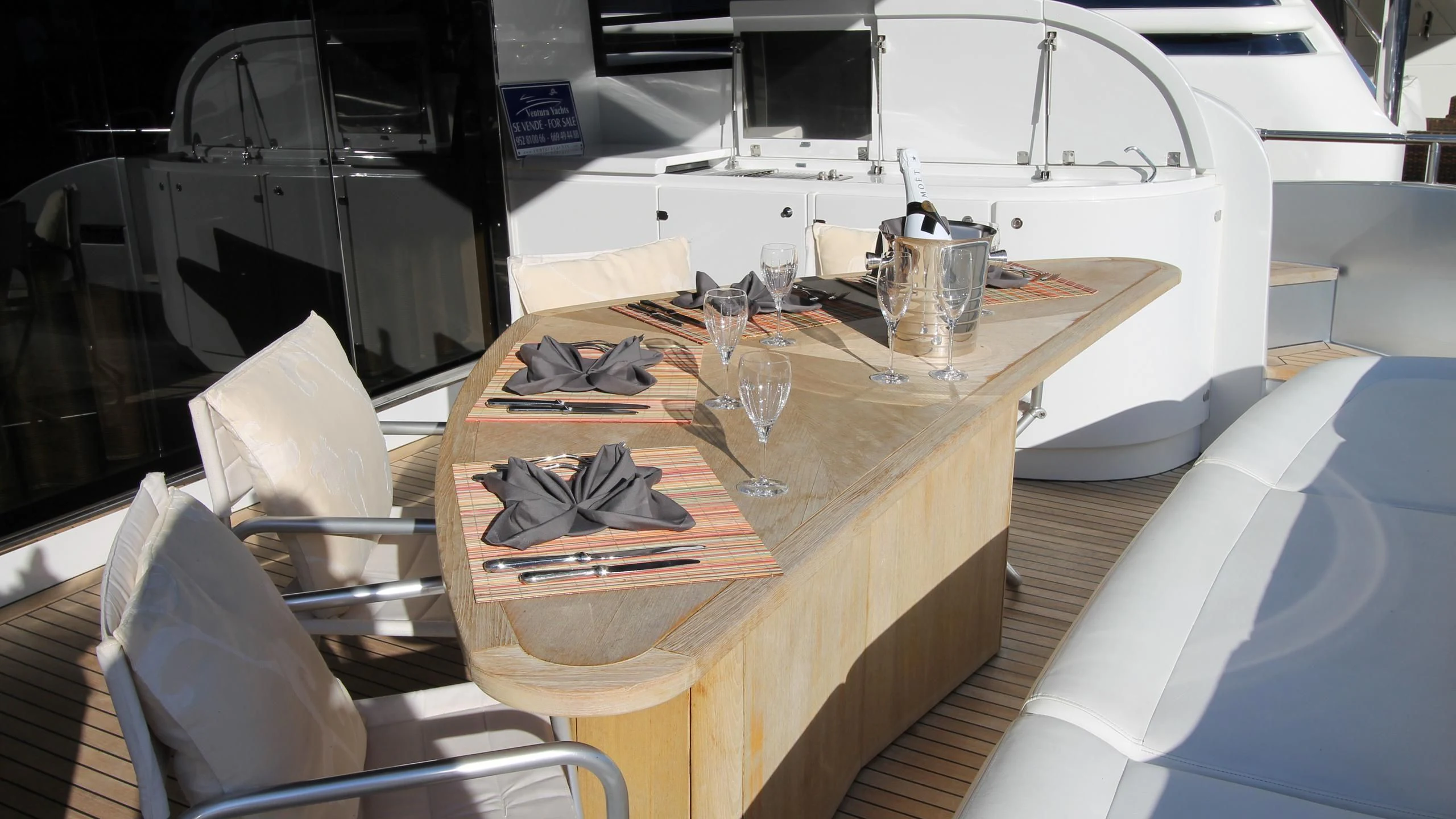 a table with chairs and a glass on it aboard A&O Yacht for Sale