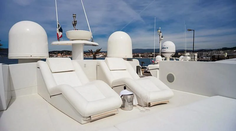 a white room with white chairs and a cross on the top aboard A&O Yacht for Sale
