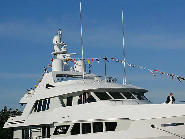 a white boat with a flag on it aboard KATHLEEN ANNE Yacht for Sale