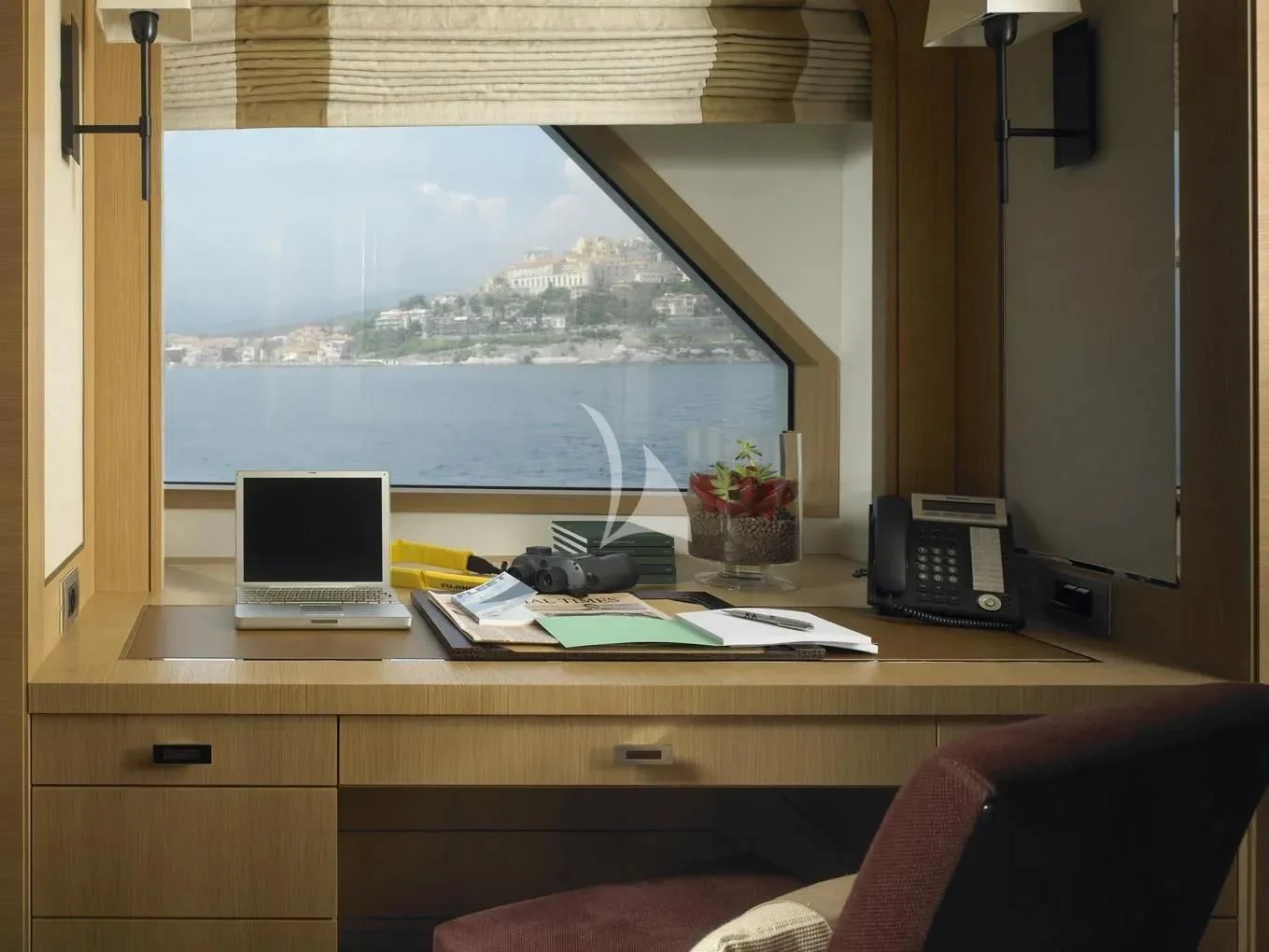 a desk with a laptop and a phone on it aboard KATHLEEN ANNE Yacht for Sale