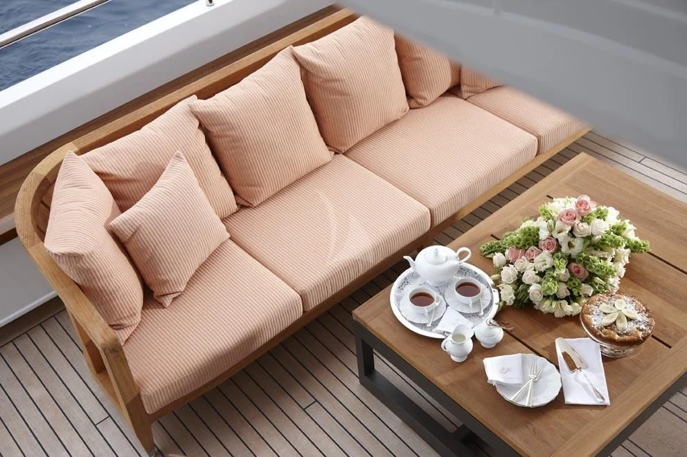 a table with a couch and a tray of food on it aboard KATHLEEN ANNE Yacht for Sale