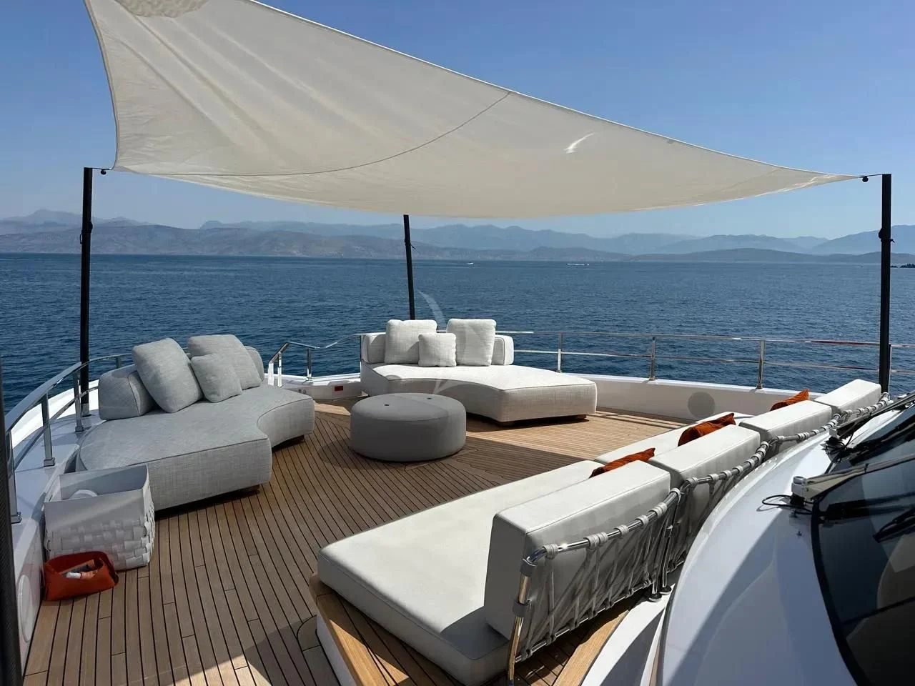 a deck with a large body of water and a large boat on it aboard AT ONE Yacht for Charter