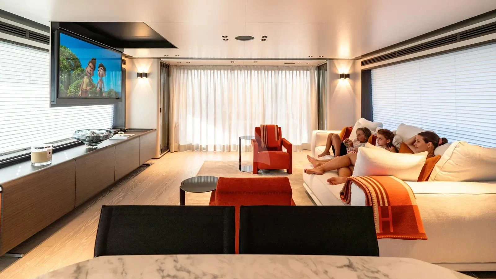 a group of people sitting on a couch in a living room aboard AT ONE Yacht for Charter