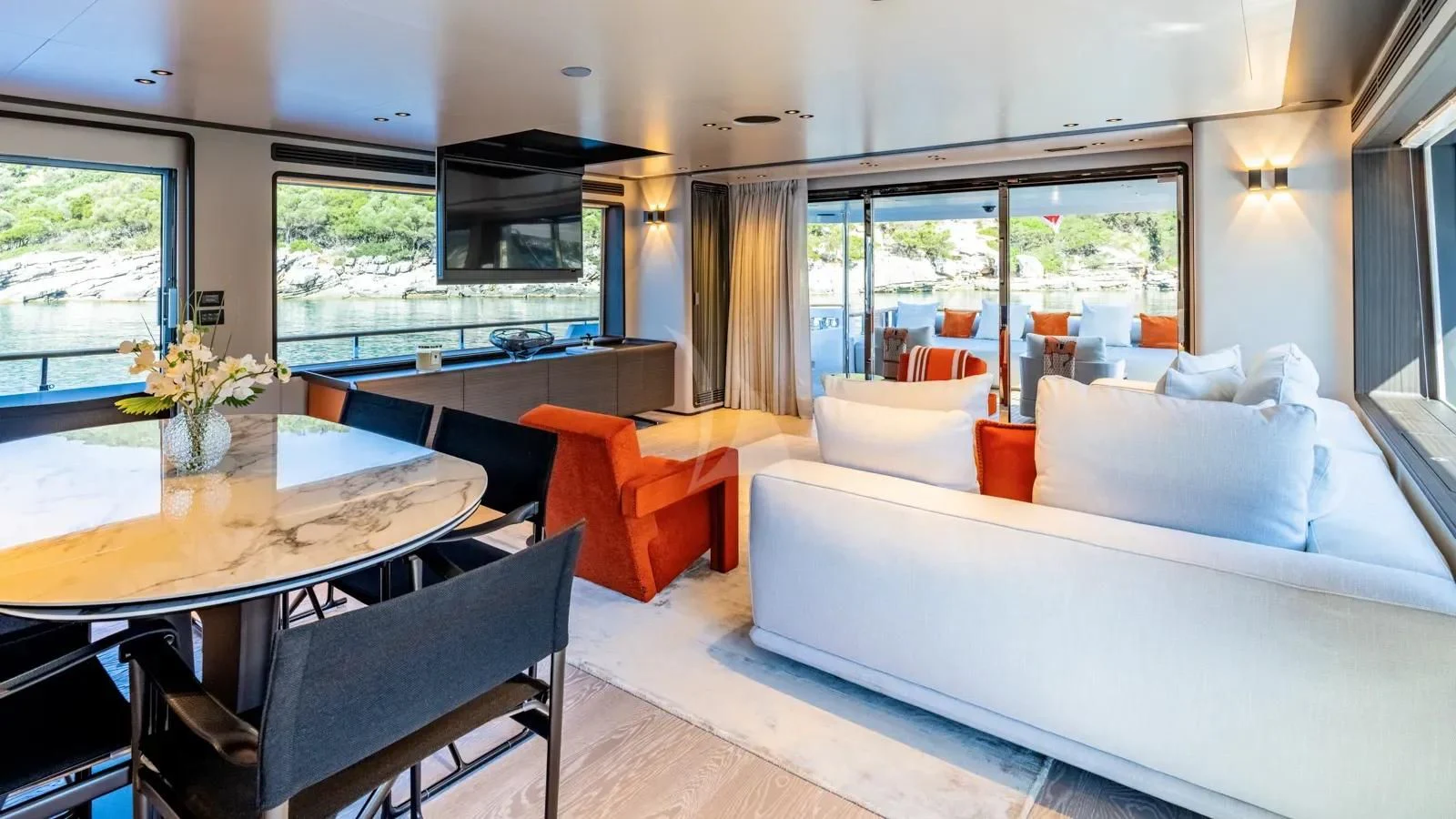 a room with a bed and a table and chairs aboard AT ONE Yacht for Charter