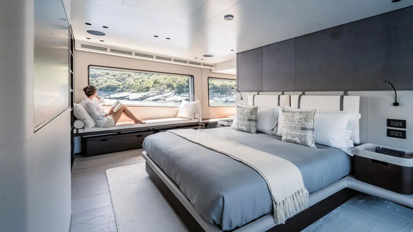 a person sitting on a bed aboard AT ONE Yacht for Charter