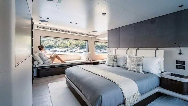 a person sitting on a bed aboard AT ONE Yacht for Charter