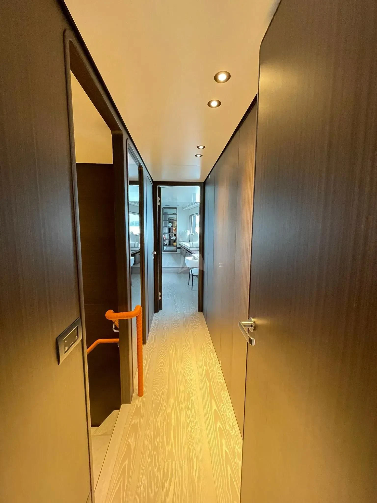 a hallway with a door and a railing aboard AT ONE Yacht for Charter