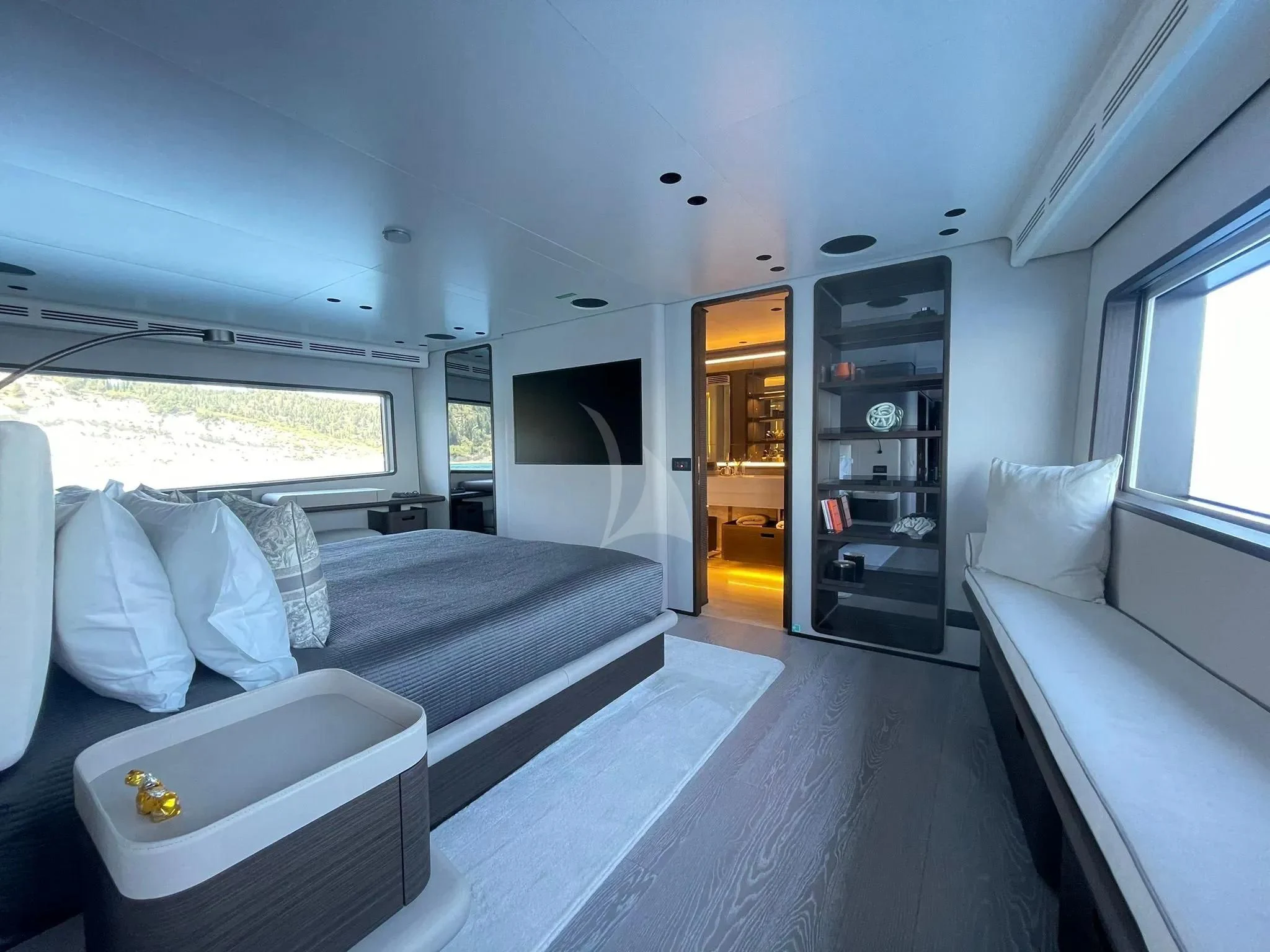 a room with a bed and a shelf with a bookcase aboard AT ONE Yacht for Charter