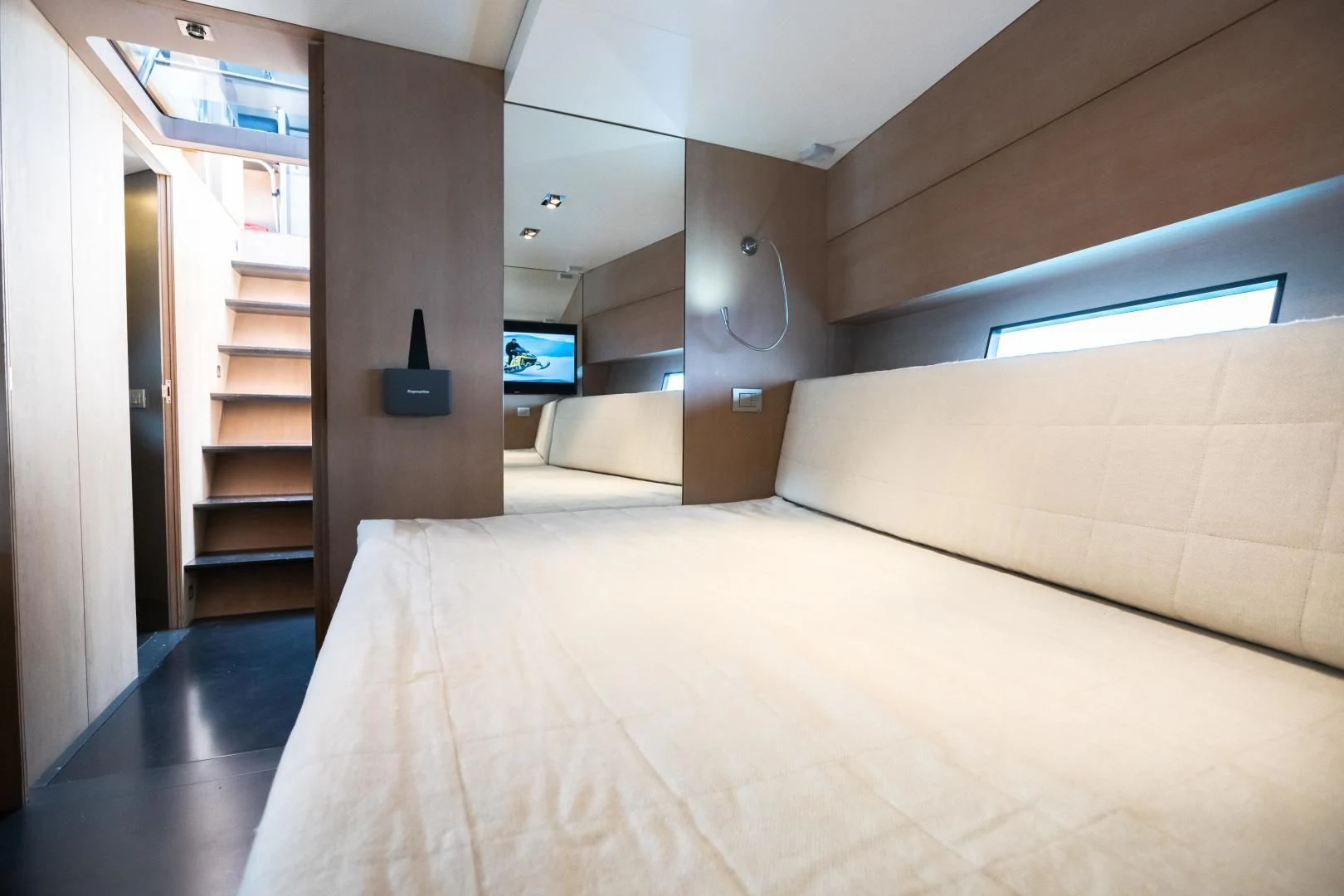 a room with a bed and a tv on the wall aboard ASH Yacht for Sale