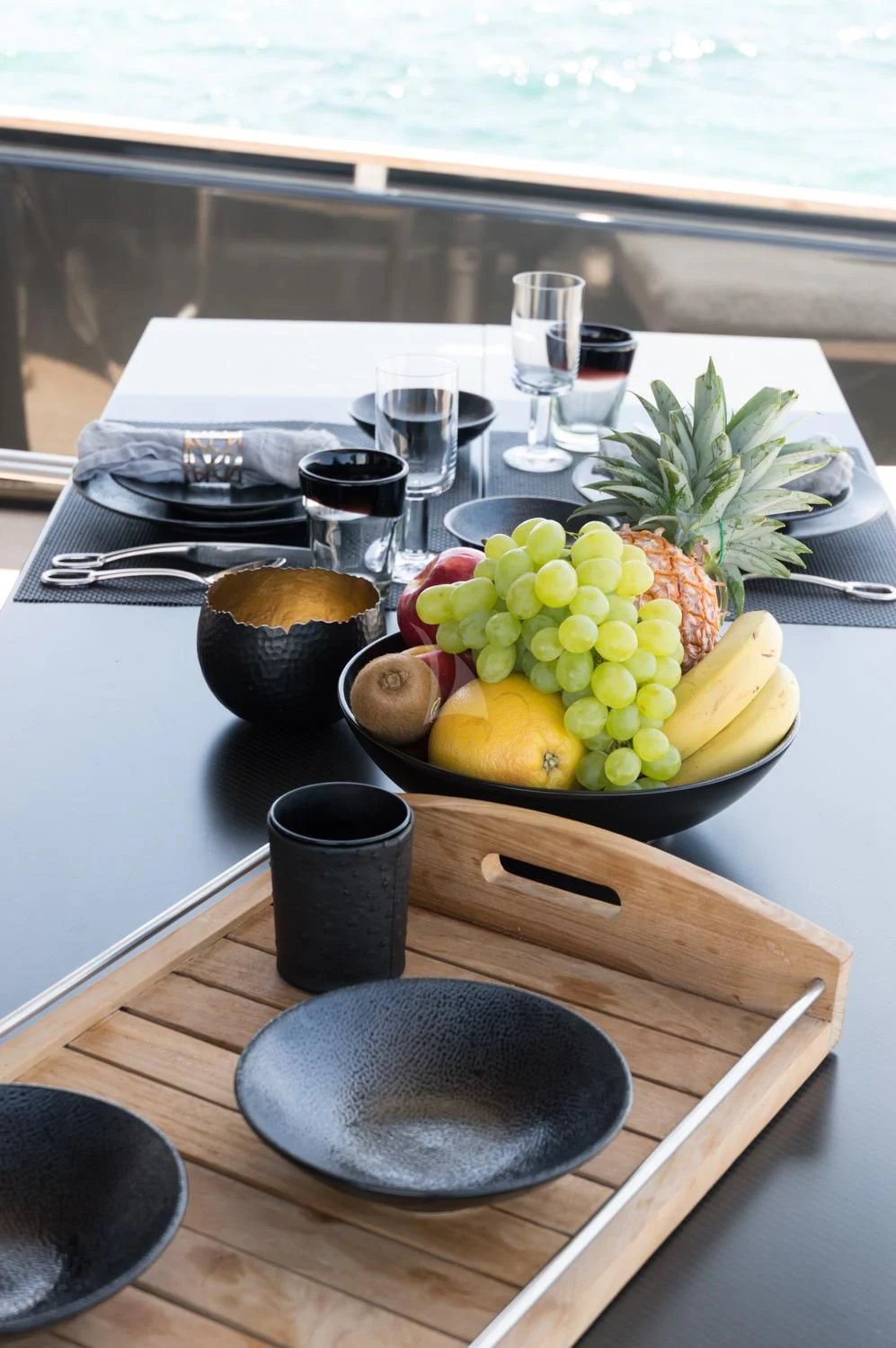 a plate of food and a bowl of fruit on a table aboard ASH Yacht for Sale