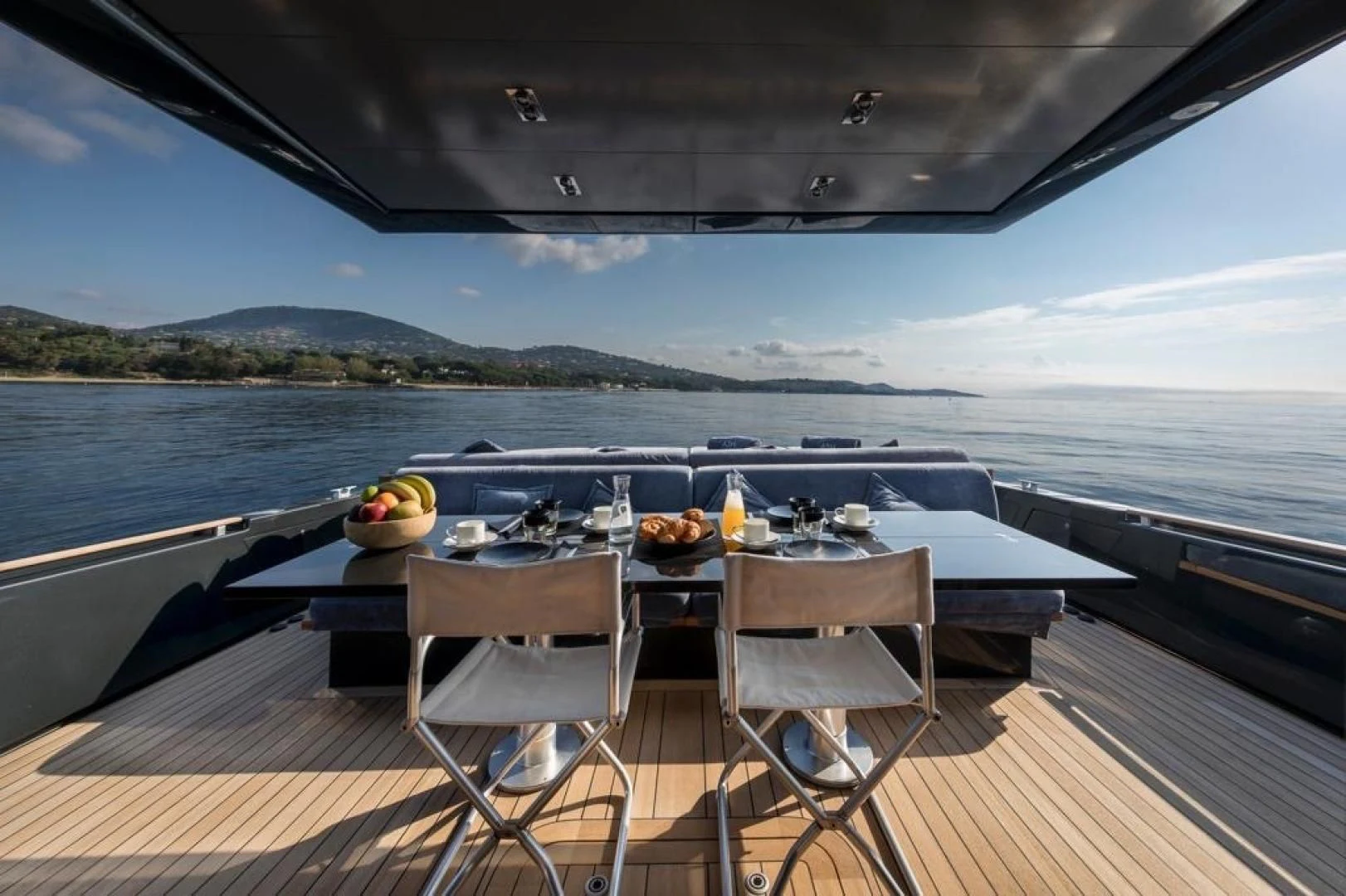 a table on a deck overlooking the ocean aboard ASH Yacht for Sale